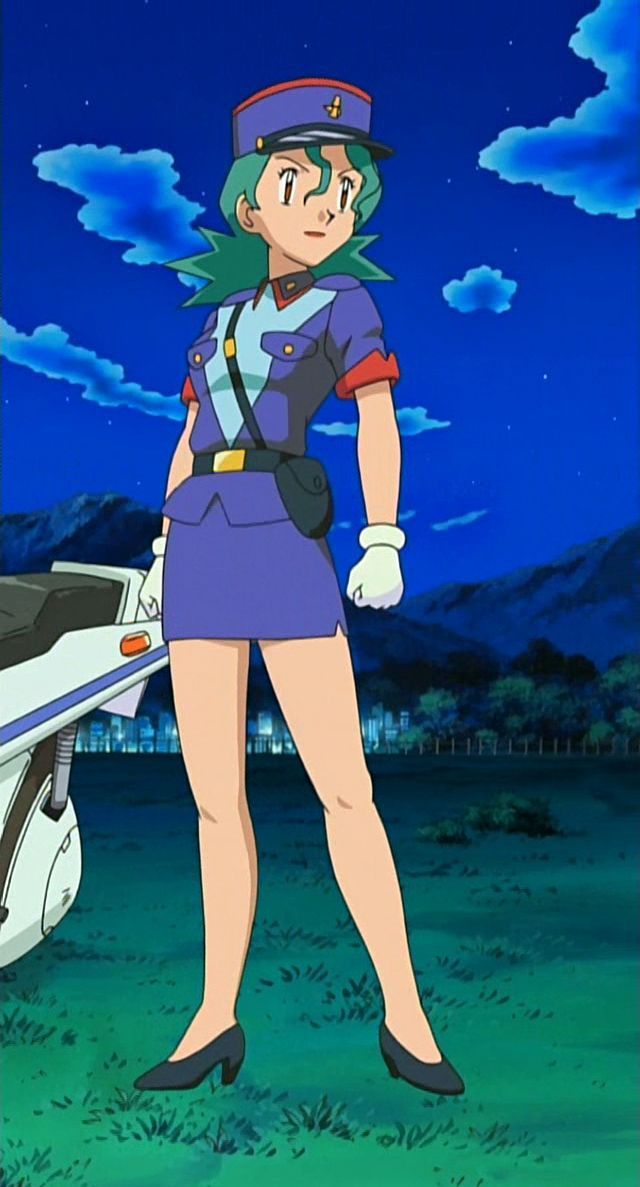 a woman in uniform standing next to a motorcycle on a field with mountains in the background