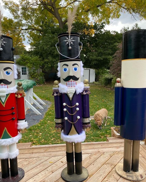 three wooden nutcrackers are standing on a deck