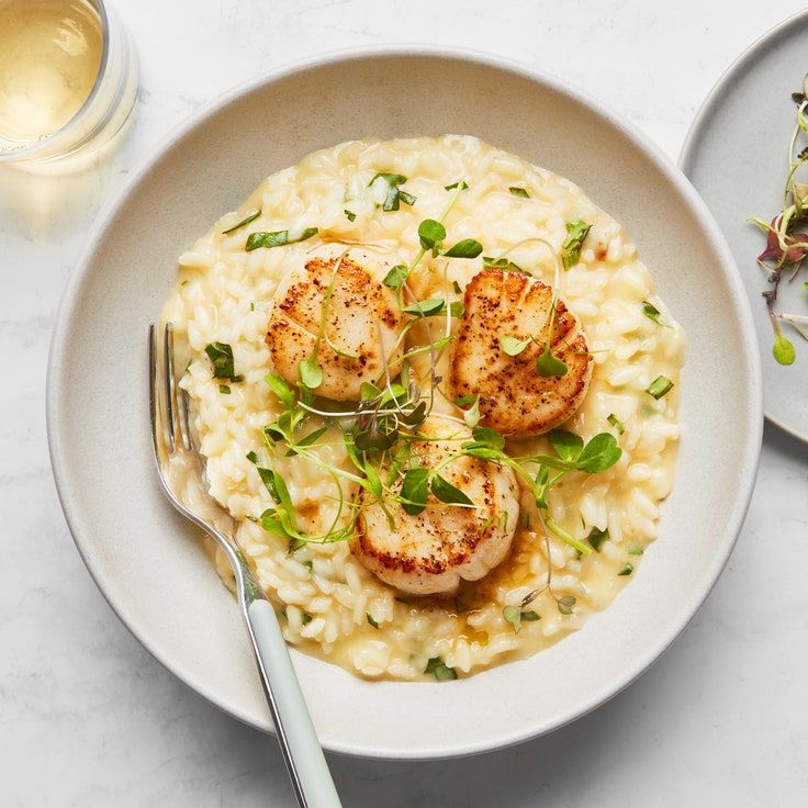 a white plate topped with pasta and scallops