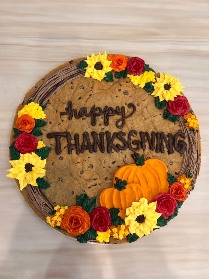 there is a cake that says happy thanksgiving with flowers and pumpkins on the side