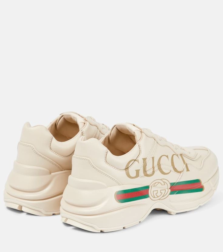 Find GUCCI Rhyton Leather Sneakers on Editorialist. Toe shape: round toe. Upper: calf leather. Sole: fabric insole, rubber sole. Closure: lace-up. Designer color name: Ivoire. Comes with a box. Made in Italy. Comes with dust bag. Gucci Rhyton, Italy Logo, Gucci Designer, Buy Gucci, Leather Trainers, Gold Print, T Shirt And Jeans, Vintage Logo, Printed Leather