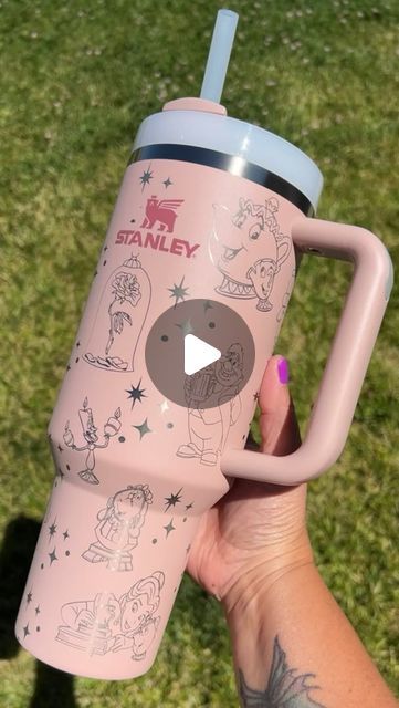 a person holding a pink cup with drawings on it and the words i am stanley