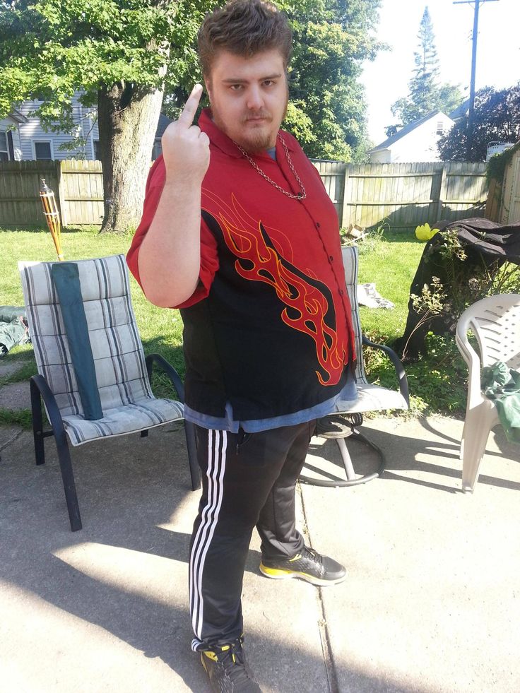 a man in black and red shirt giving the peace sign