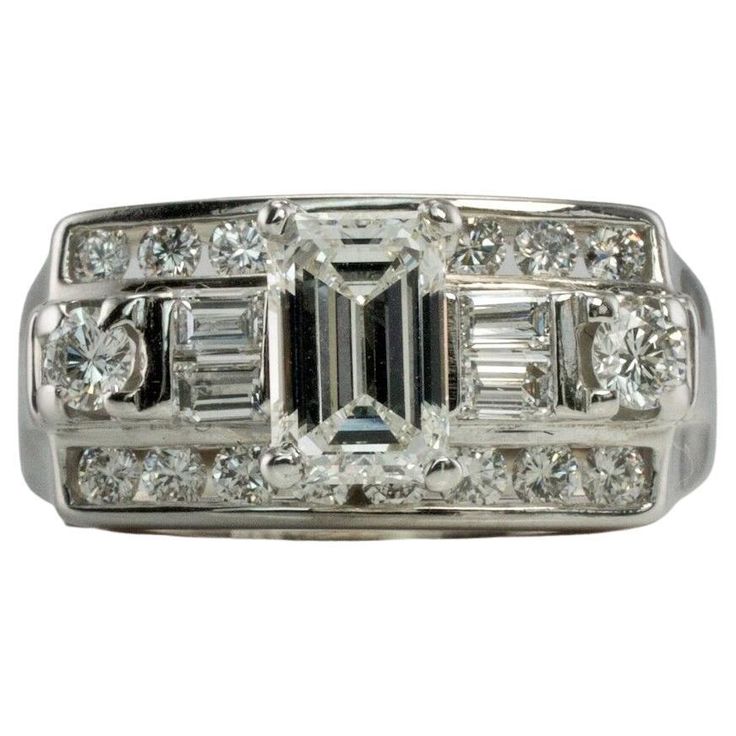 This gorgeous Vintage elegant ring is finely crafted in solid 14K White Gold and set with white and fiery genuine diamonds. The center emerald cut diamond is .50 carat. Four diamond baguettes .20 carats. Eighteen round brilliant cut diamonds total .44 carats. The diamonds are VS1 clarity and FG color for a grand total of (1.14cttw) The top of this genuine diamond ring measures 9mm North-South. The setting elevates 9mm high above the finger. This stylish ring is size 7.25 (can be resized) Total w Diamond Ring With Baguette Diamonds In Octagon Shape, Art Deco Emerald Cut Diamond Ring With Baguette Diamonds, Classic Emerald Ring With Diamond Cut In Diamond White, Classic Diamond White Emerald Ring, Classic Emerald Ring With Diamond Accents And Octagon Shape, Timeless Diamond White Emerald Cut Ring, Classic Octagon Emerald Ring With Diamond Accents, Diamond White Emerald Cut Emerald Ring With Diamond Accents, Timeless Emerald Cut Ring In Diamond White