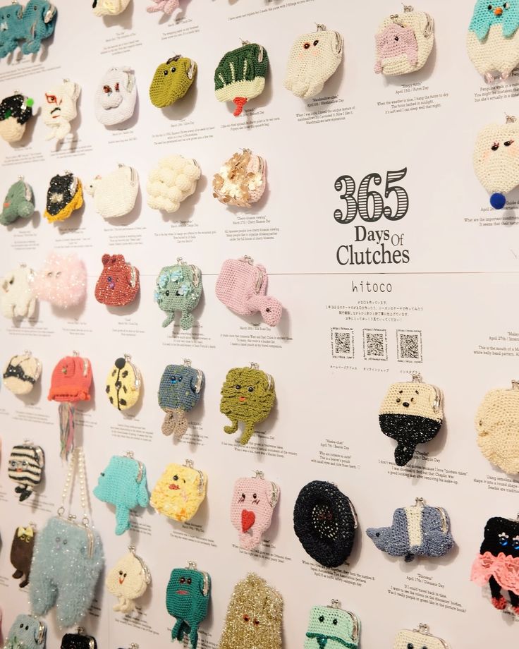 there are many small crocheted animals on the display wall, all in different colors and sizes