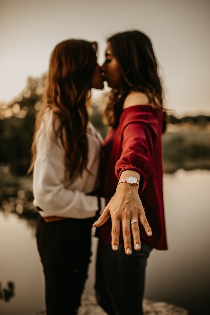 two women standing next to each other with their hands in the air