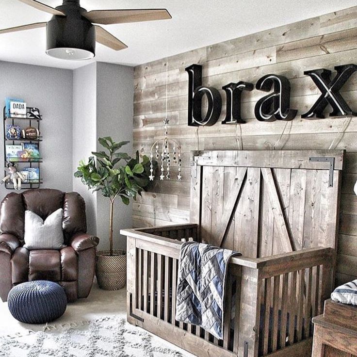 a baby's room with a chair, crib and large wooden letters on the wall