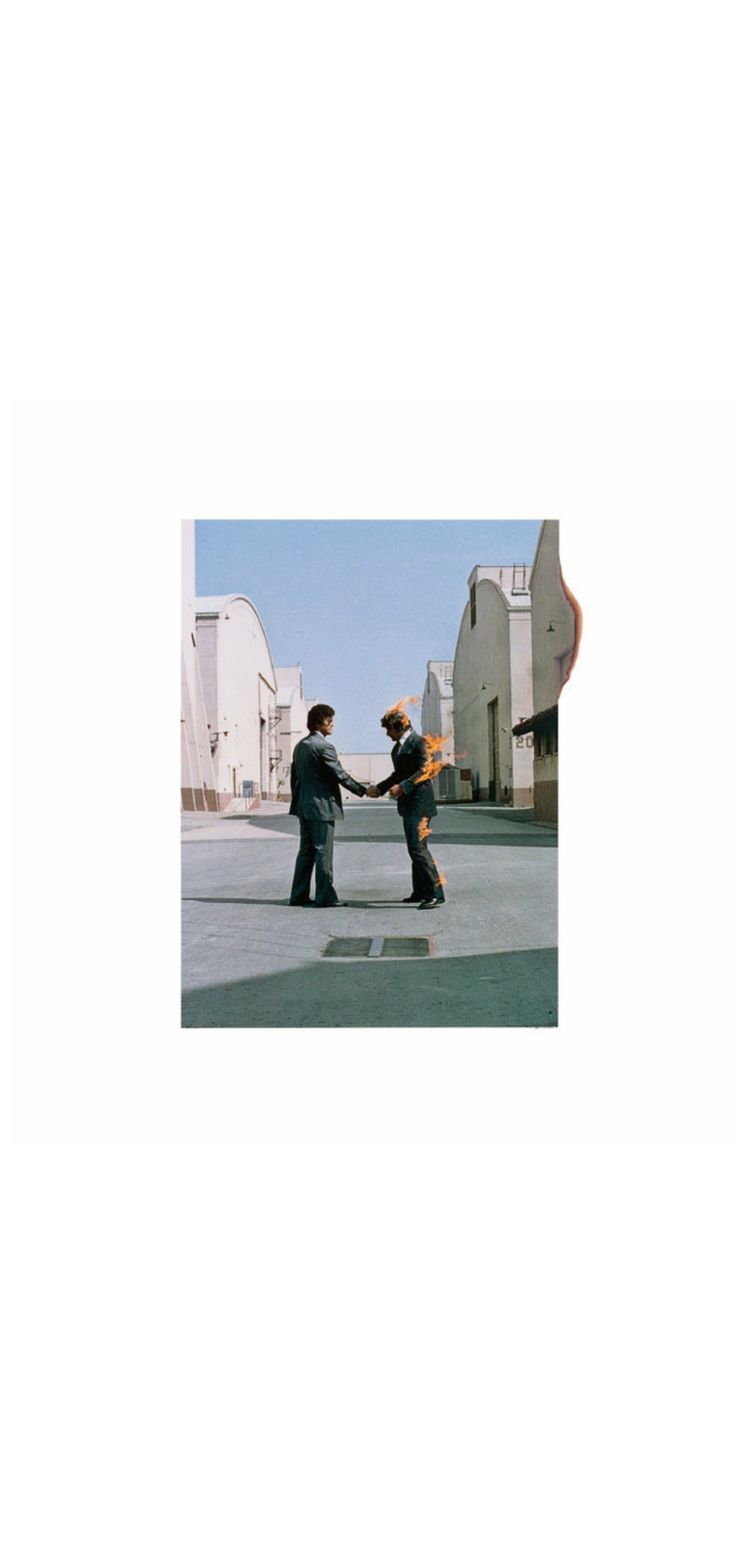 two people are shaking hands in the middle of an empty parking lot with buildings behind them