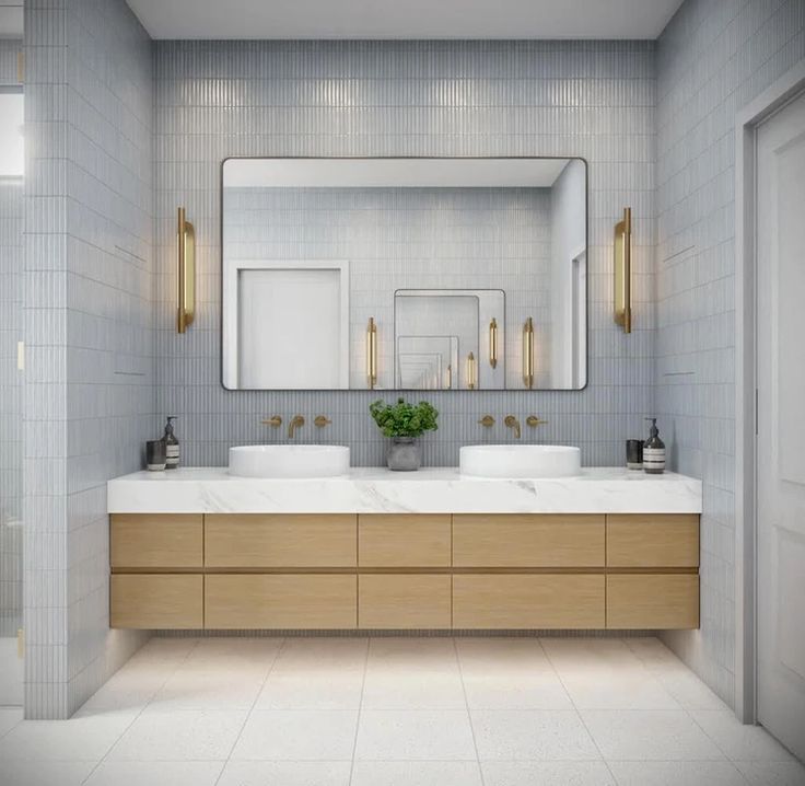 a bathroom with two sinks, mirrors and lights on the wall above them is shown