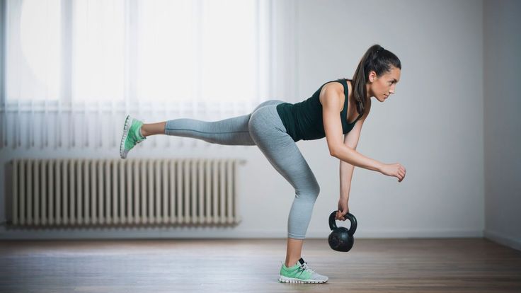 a woman is doing an exercise with a kettle while holding her leg in the air