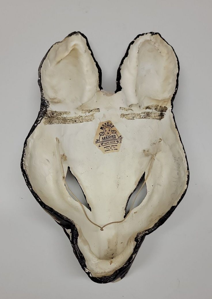 an animal's head is shown in white and black with gold details on it