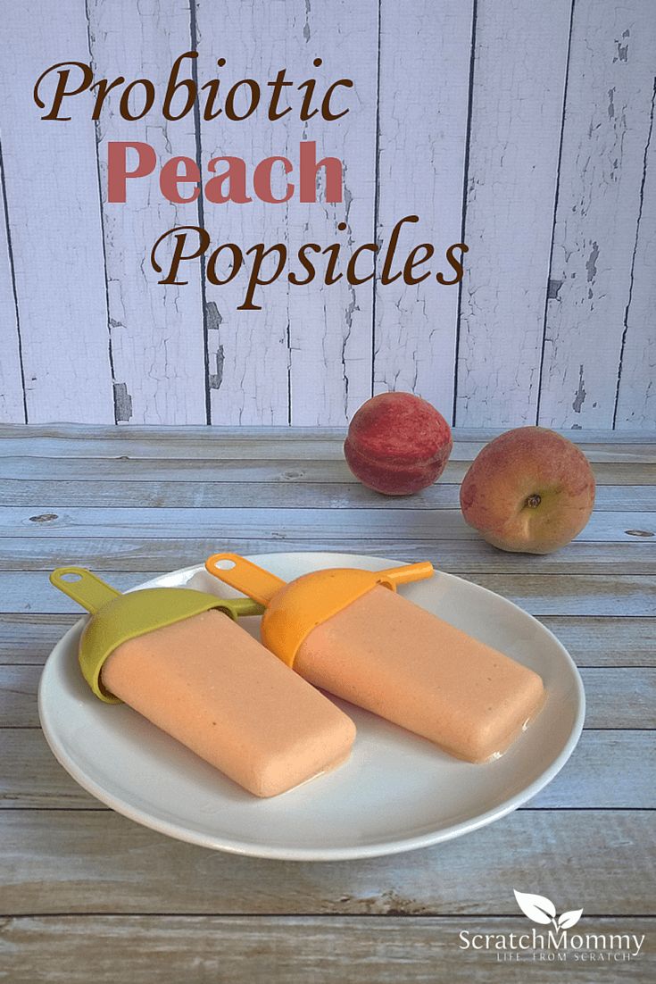 two popsicles sitting on top of a white plate next to an apple and banana