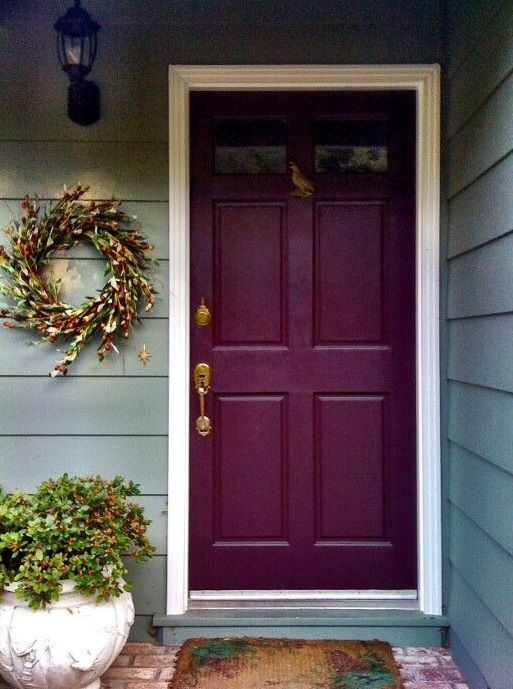 a purple front door with a wreath on it