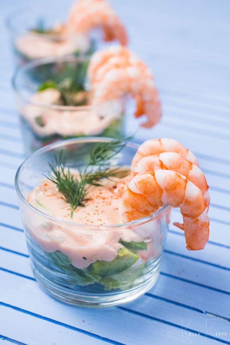 three small bowls filled with shrimp and garnish