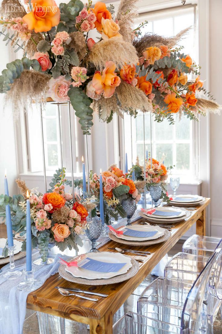 a dining room table set with plates and flowers