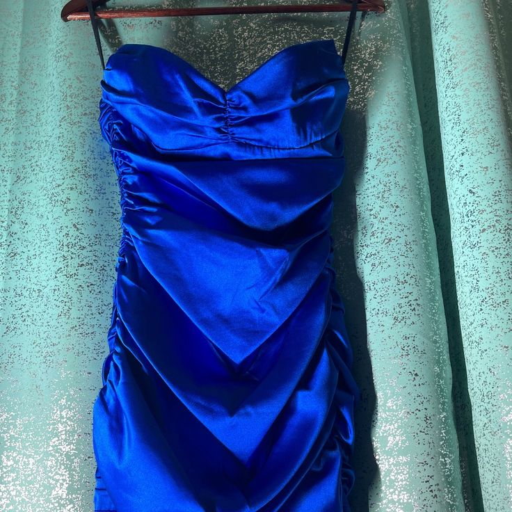 a blue dress hanging on a clothes rack