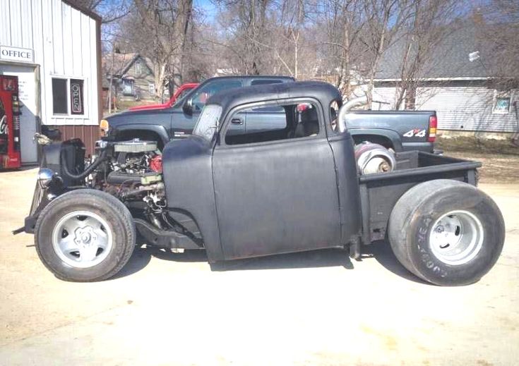 an old black truck parked in front of a building