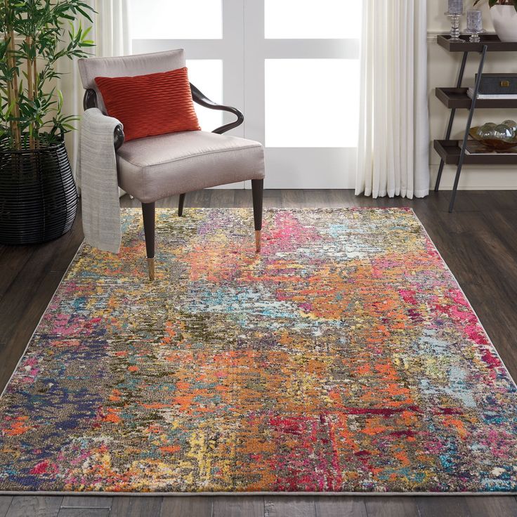 a colorful area rug with a chair and potted plant in the corner next to it