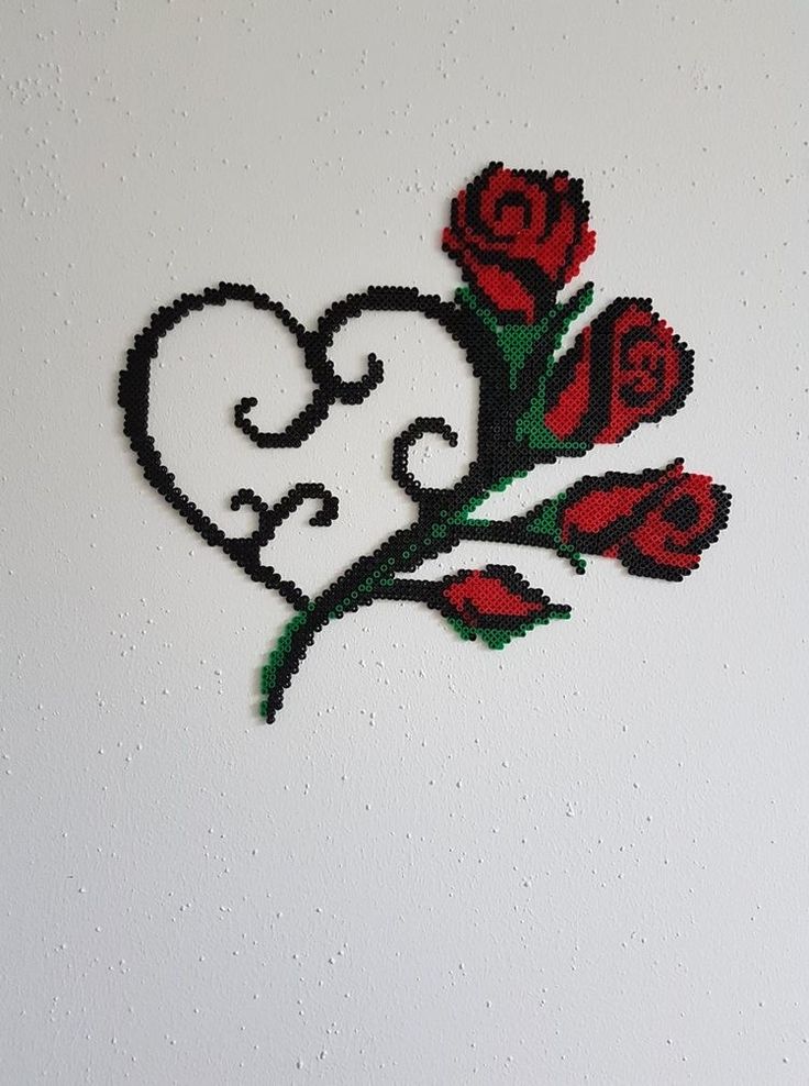 a cross stitched heart with roses on the side is shown in black and white