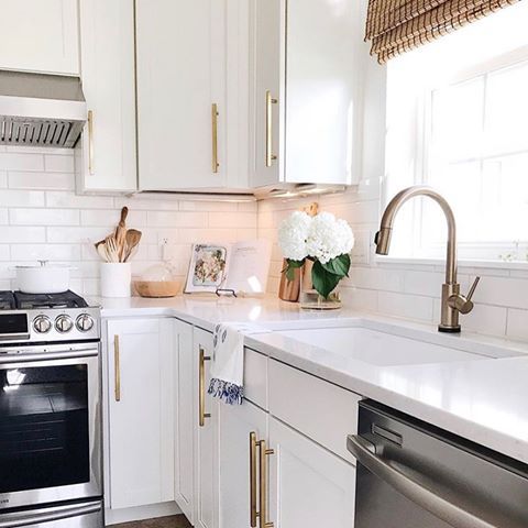 a kitchen with white cabinets and stainless steel appliances, including an oven, dishwasher, sink, stove top and microwave