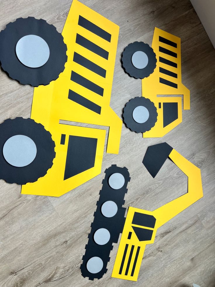 construction vehicles cut out from construction paper on the floor