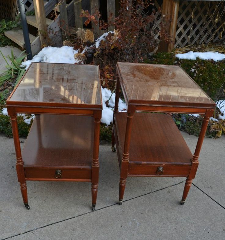 two wooden tables sitting on top of a sidewalk covered in snow