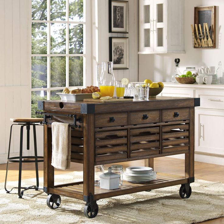 a kitchen island cart with plates and cups on it