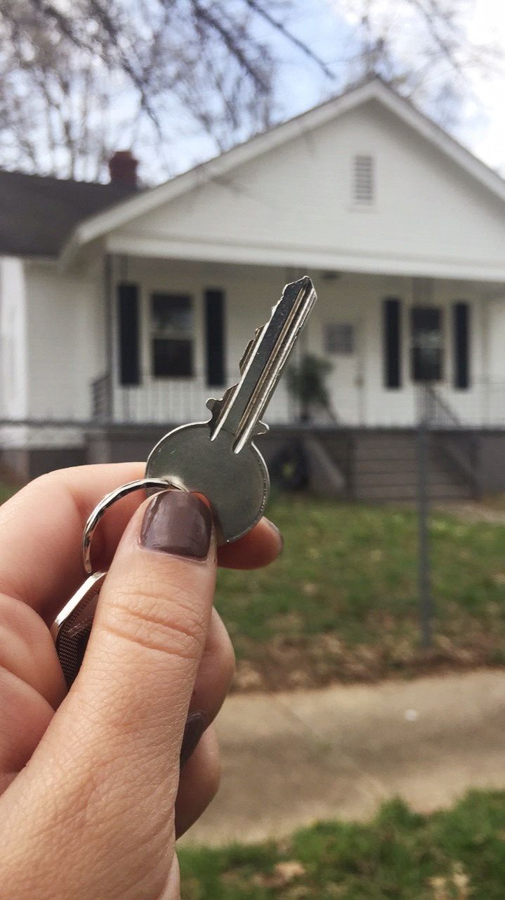 a person holding a key in front of a house