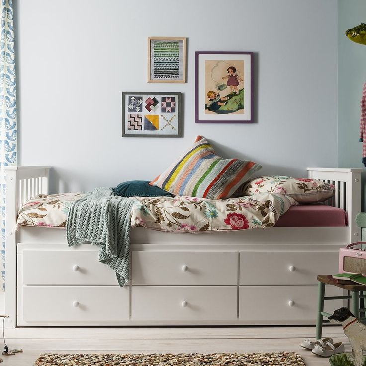 a bedroom with a bed, dresser and pictures on the wall