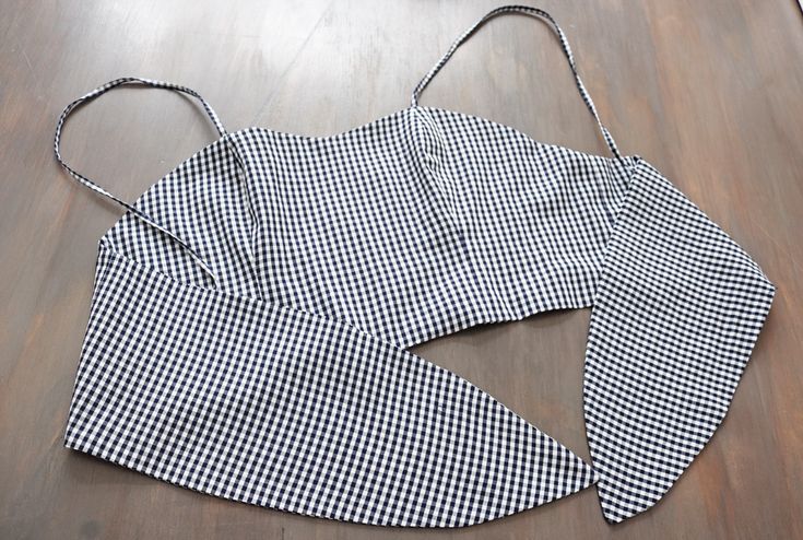 a black and white checkered apron sitting on top of a wooden floor