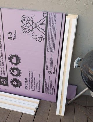 a purple box sitting on top of a wooden floor next to a grill