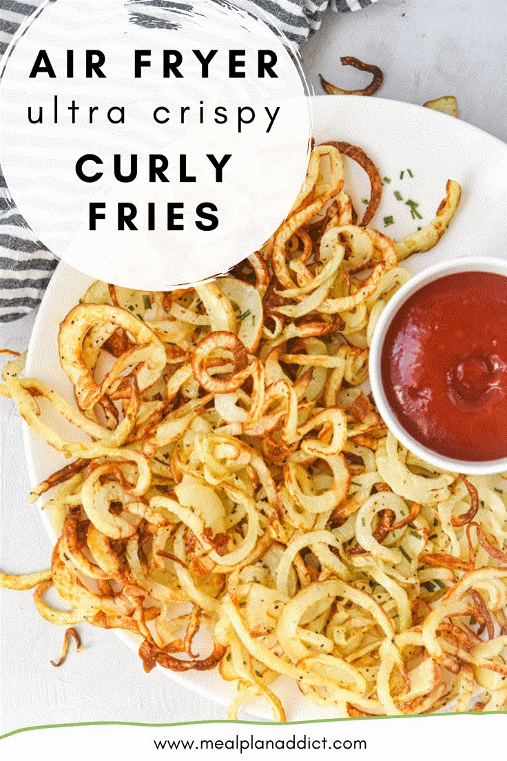 an air fryer is being served with curly fries and ketchup on the side