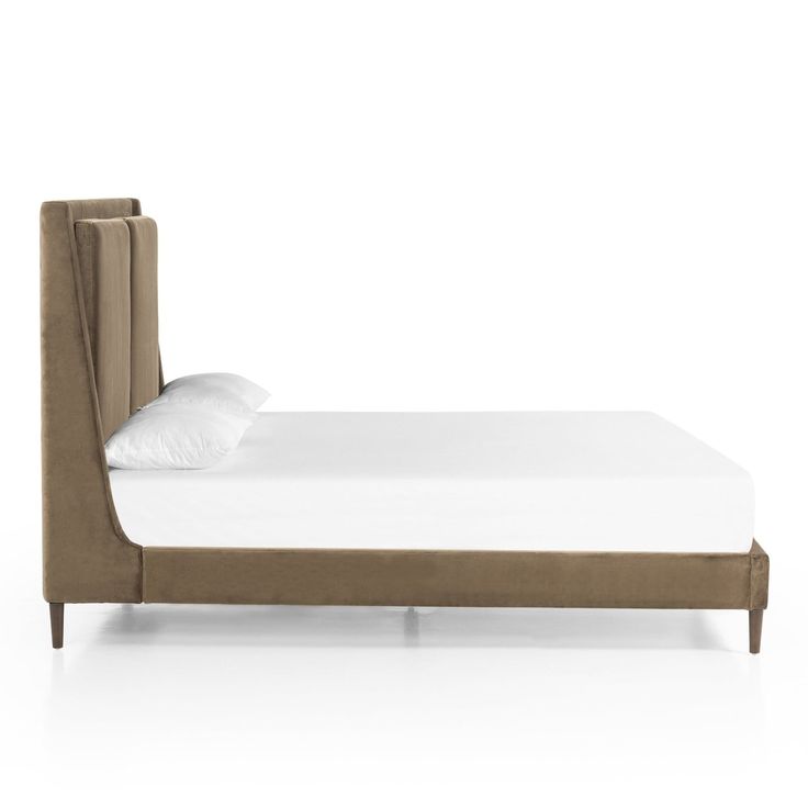 an upholstered bed frame with white sheets and pillows on the headboard is shown