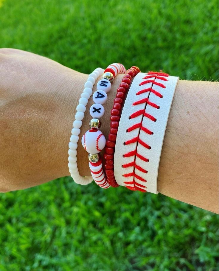 a person's arm with three bracelets on top of it, and two balls in the middle