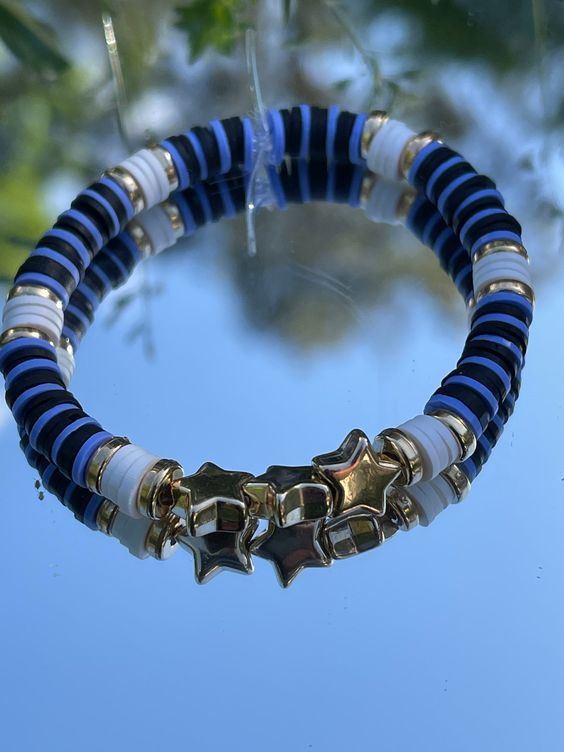 a blue and white beaded bracelet with gold stars hanging from it's center