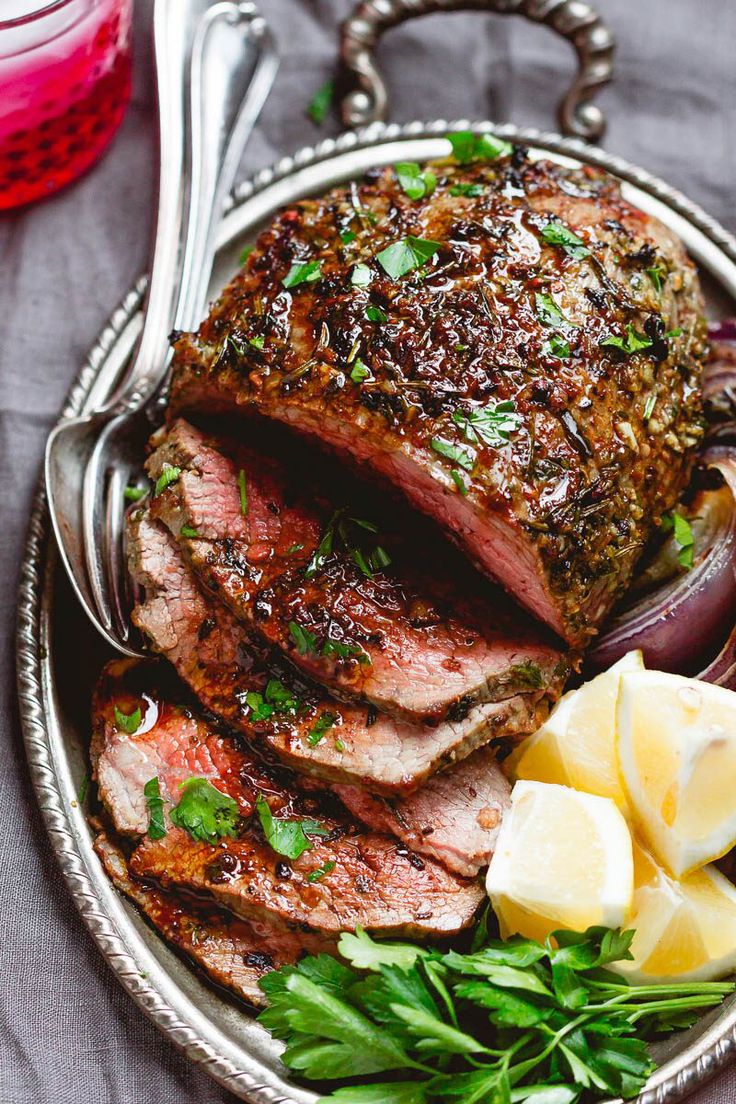 a plate filled with meat and vegetables on top of a table next to a fork