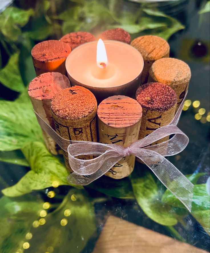 a candle that is sitting on top of some wine corks with a ribbon around it