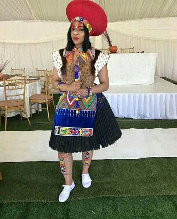 a woman wearing a colorful dress and hat