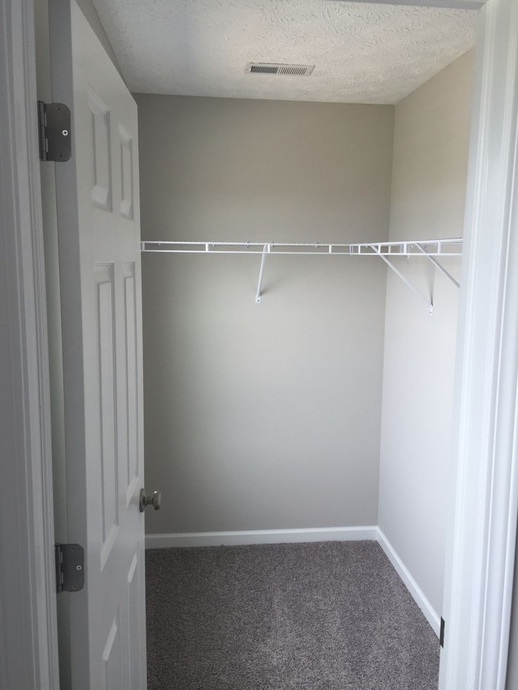 an empty room with a white closet and gray carpet