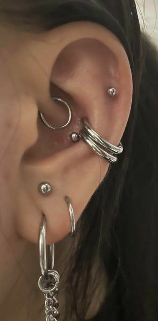 a close up of a person wearing ear piercings with chains attached to their ears