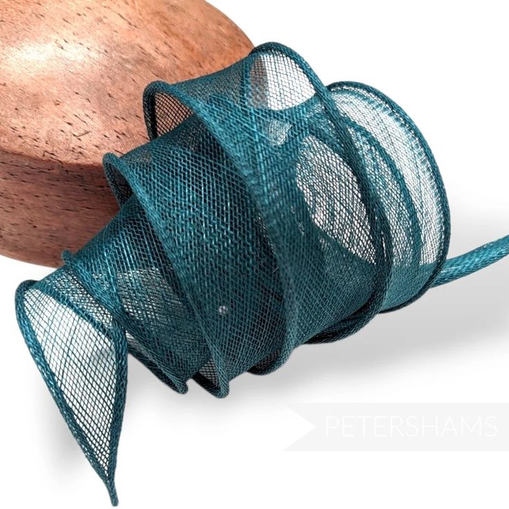 a piece of green mesh next to a wooden object