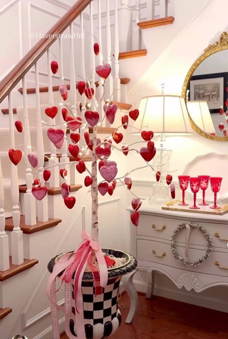 there is a tree with hearts on it in the corner next to a dresser and mirror