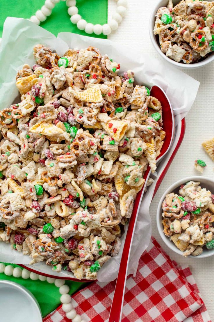 a bowl filled with cereal salad next to two small bowls full of candy canes