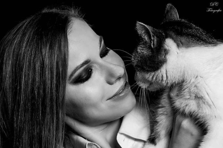 a woman holding a cat in her arms and looking at it's own face