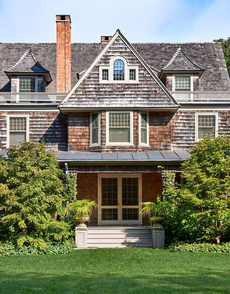 a large brown house sitting on top of a lush green field