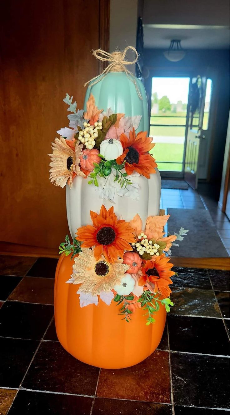 an orange and white pumpkin decorated with flowers