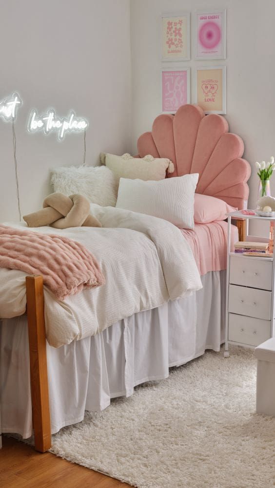 a bedroom with a bed, dresser and white carpeted flooring in front of a pink scallop headboard