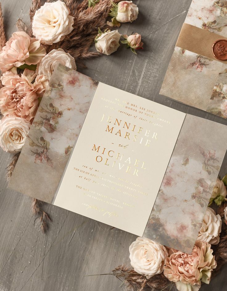 the wedding stationery is laid out on top of some dried flowers and other items