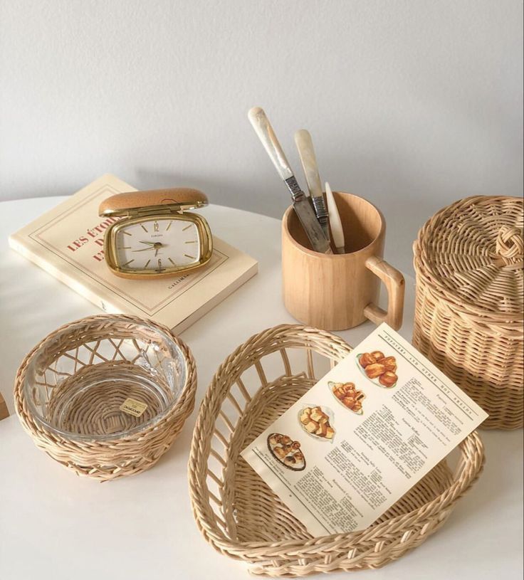 wicker baskets with utensils on a table next to a clock and other items