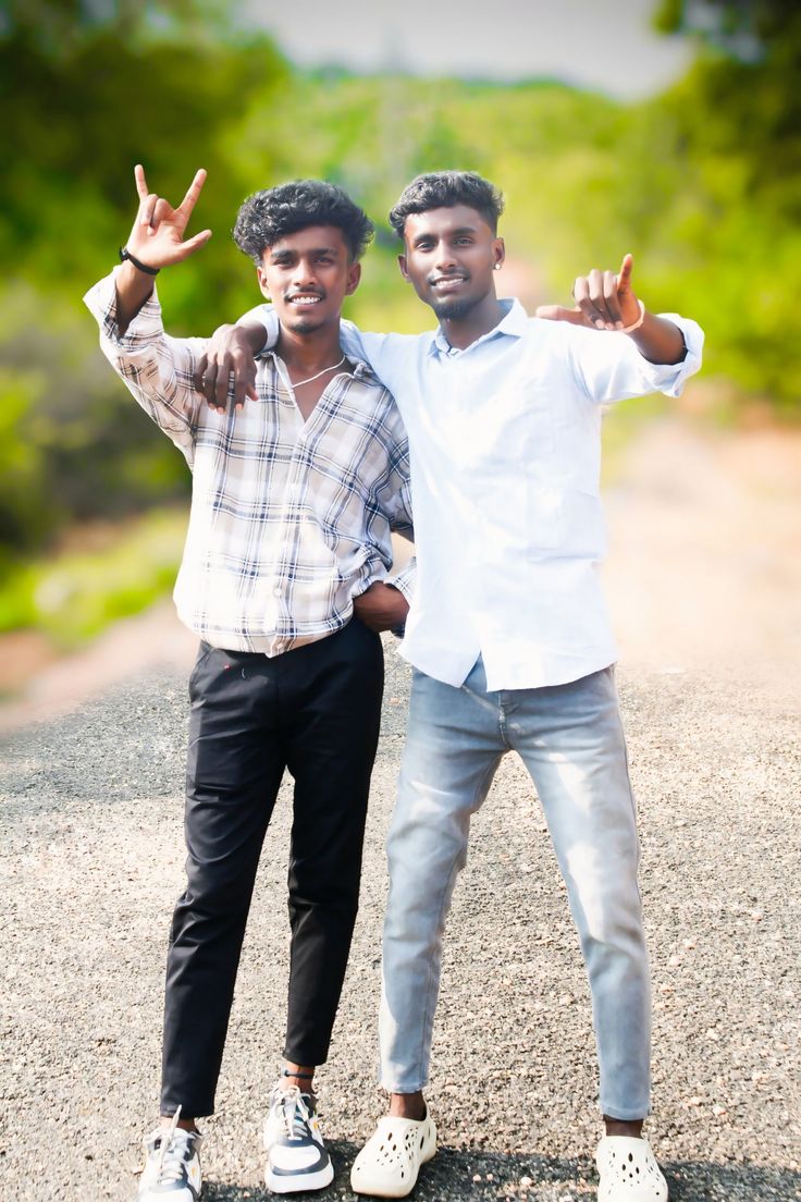 two young men posing for the camera with their hands in the air